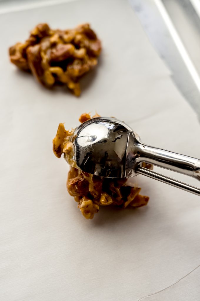 Someone is using a cookie scoop to portion out turtle candy.