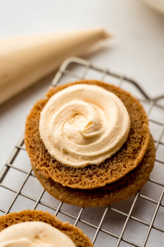 Biscoff cookies with butterscotch marshmallow frosting piped onto them to make cookie sandwiches.