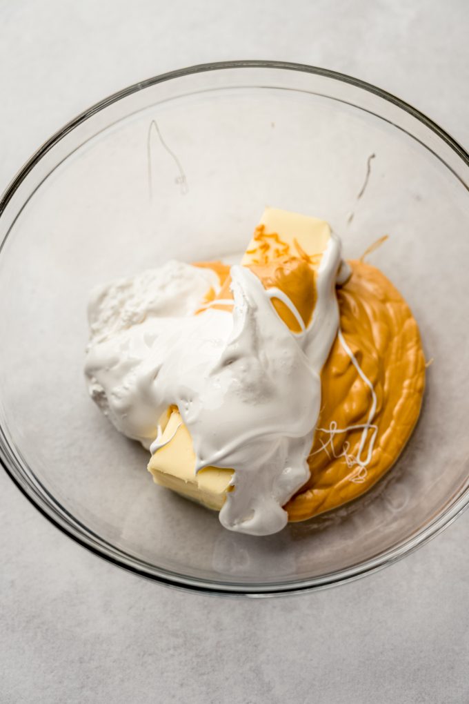 A bowl of butter, melted butterscotch chips, and marshmallow fluff to make butterscotch marshmallow frosting.