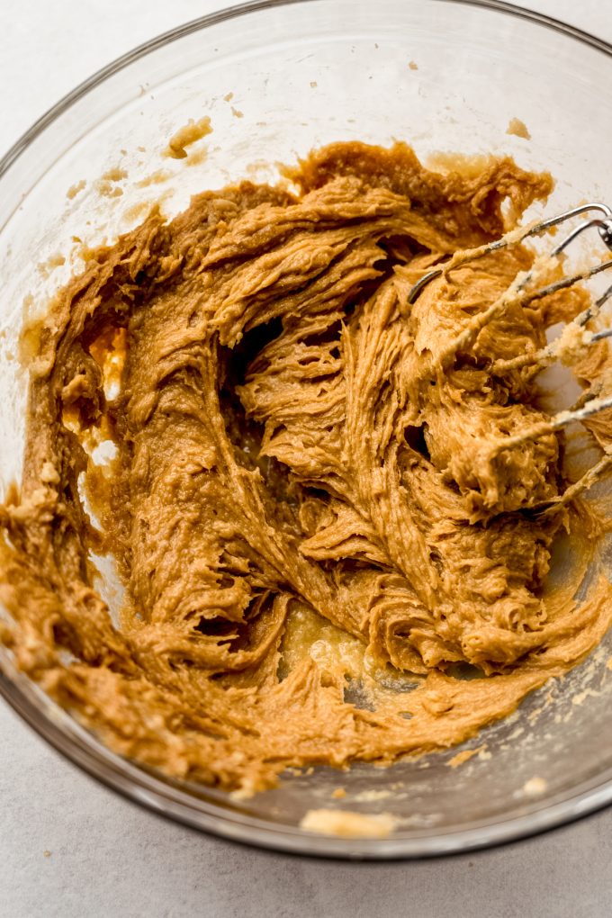 Biscoff cookie dough in a bowl with electric beaters.