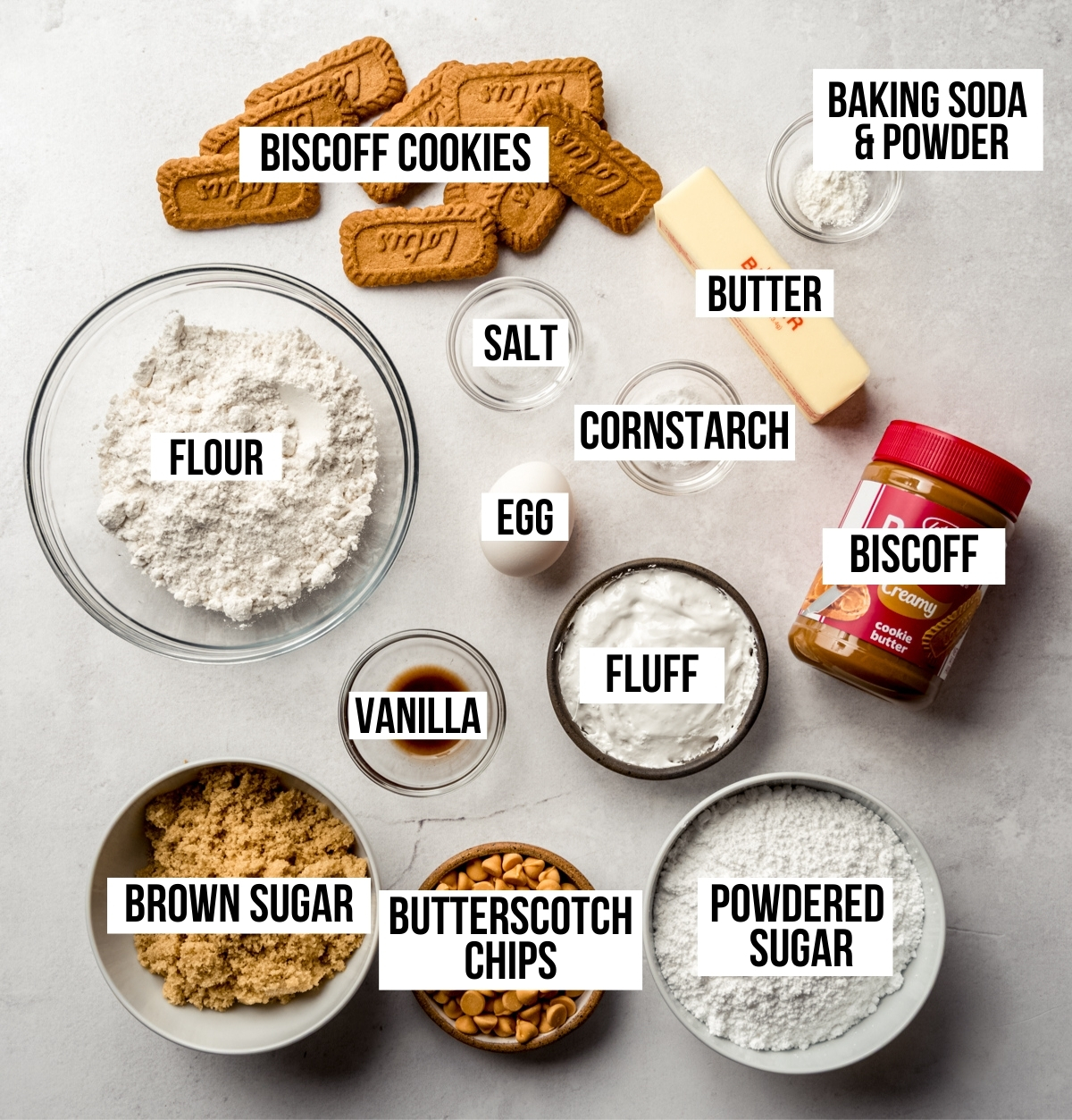 Aerial photo of ingredients to make Biscoff butterscotch marshmallow sandwich cookies with text overlay labeling each ingredient.
