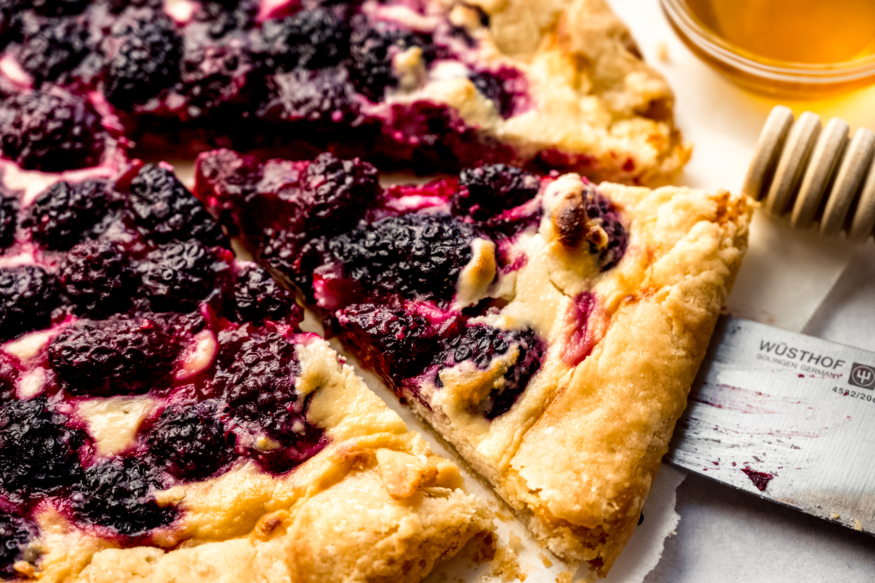 Aerial photo of a blackberry galette that has been sliced.