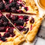 Aerial photo of a blackberry galette that has been sliced.