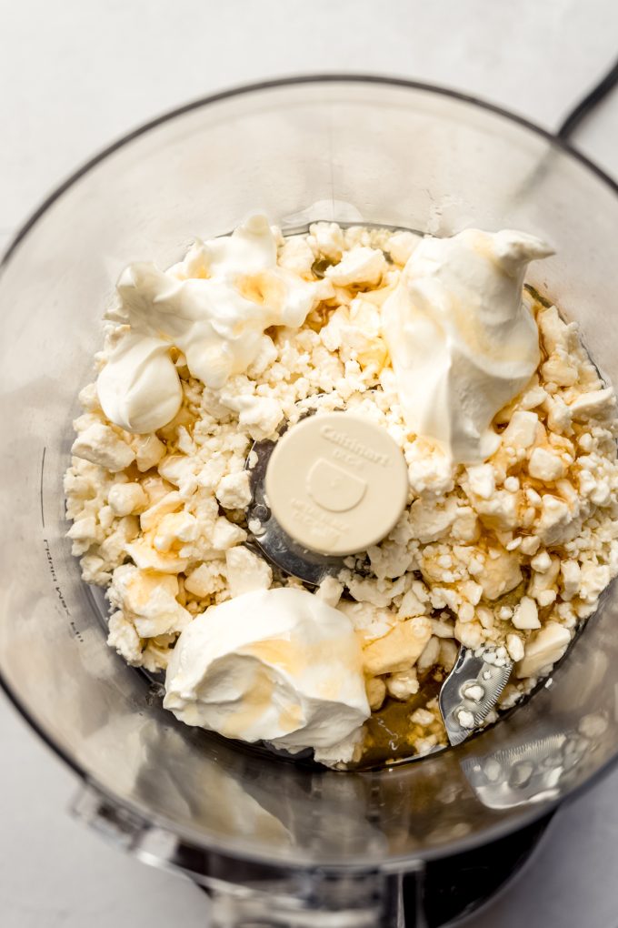 The ingredients for whipped feta in the drum of a food processor.