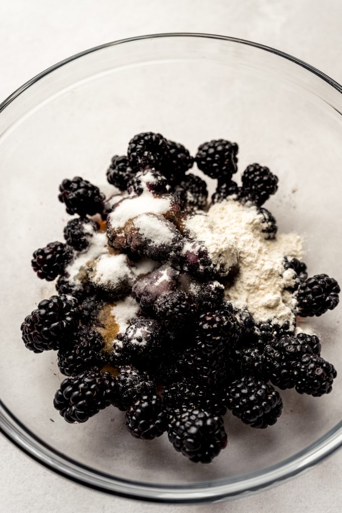A bowl of blackberries, flour, and honey.