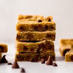 A stack of chocolate chip cookie bars on a surface.