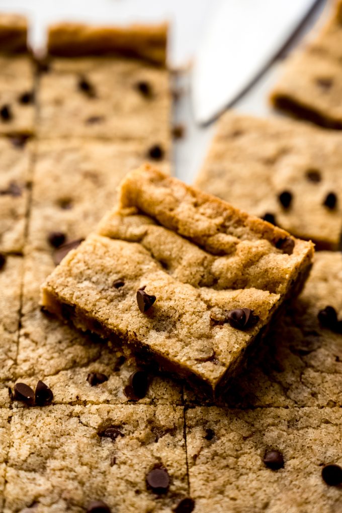 Chocolate chip cookie bars on a surface.