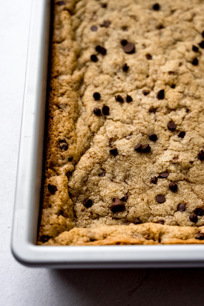 Chocolate chip cookie bars in a pan before being sliced.