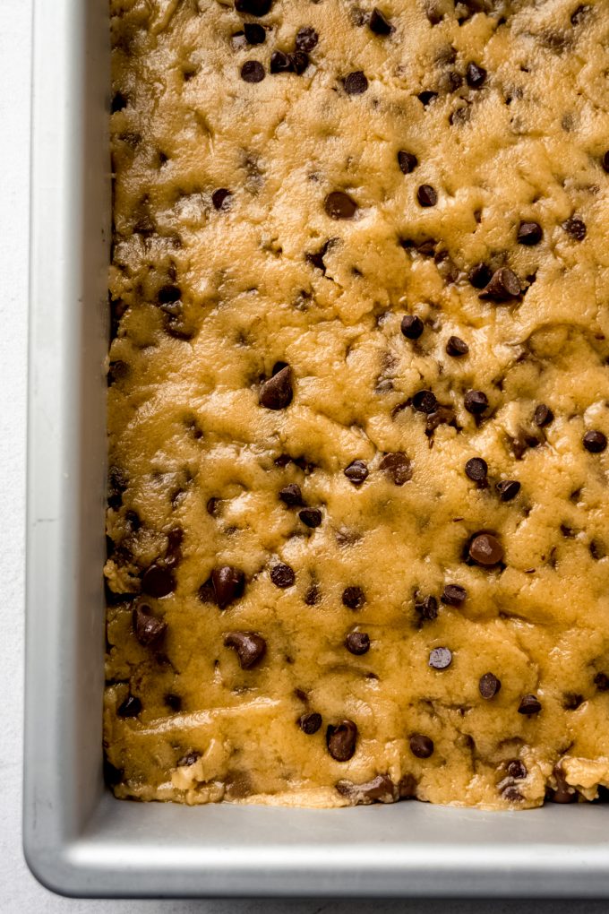 Aerial photo of chocolate chip cookie bar dough pressed into a pan.