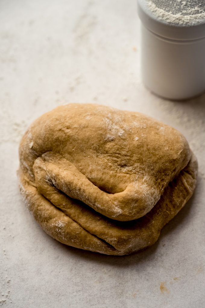 Gingerbread cinnamon roll dough on a surface after kneading.