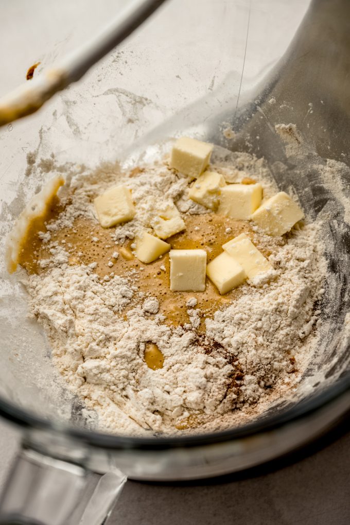 Gingerbread cinnamon roll dough ingredients in a bowl of a mixer.