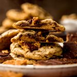 A stack of graham cracker toffee cookies and the one on top has been cut in half so you can see the cross section of the cookie.