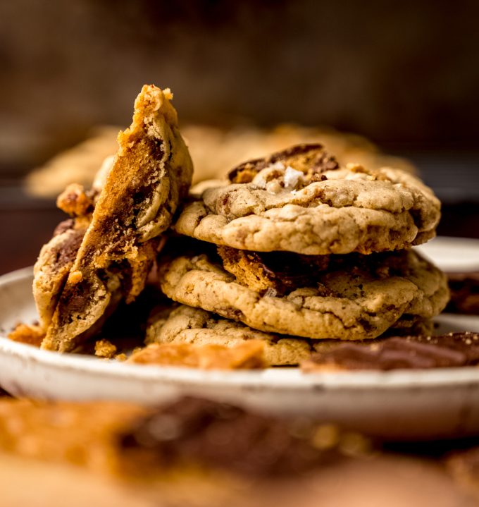 A stack of graham cracker toffee cookies and the one leaning on its side has been cut in half so you can see the cross section of the cookie.
