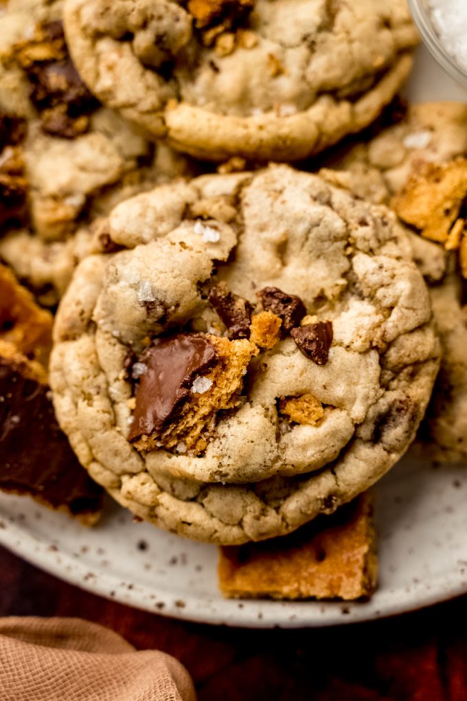 Aerial photo of a plate of graham cracker toffee cookies with a small bowl of sea salt and pieces of toffee on it.