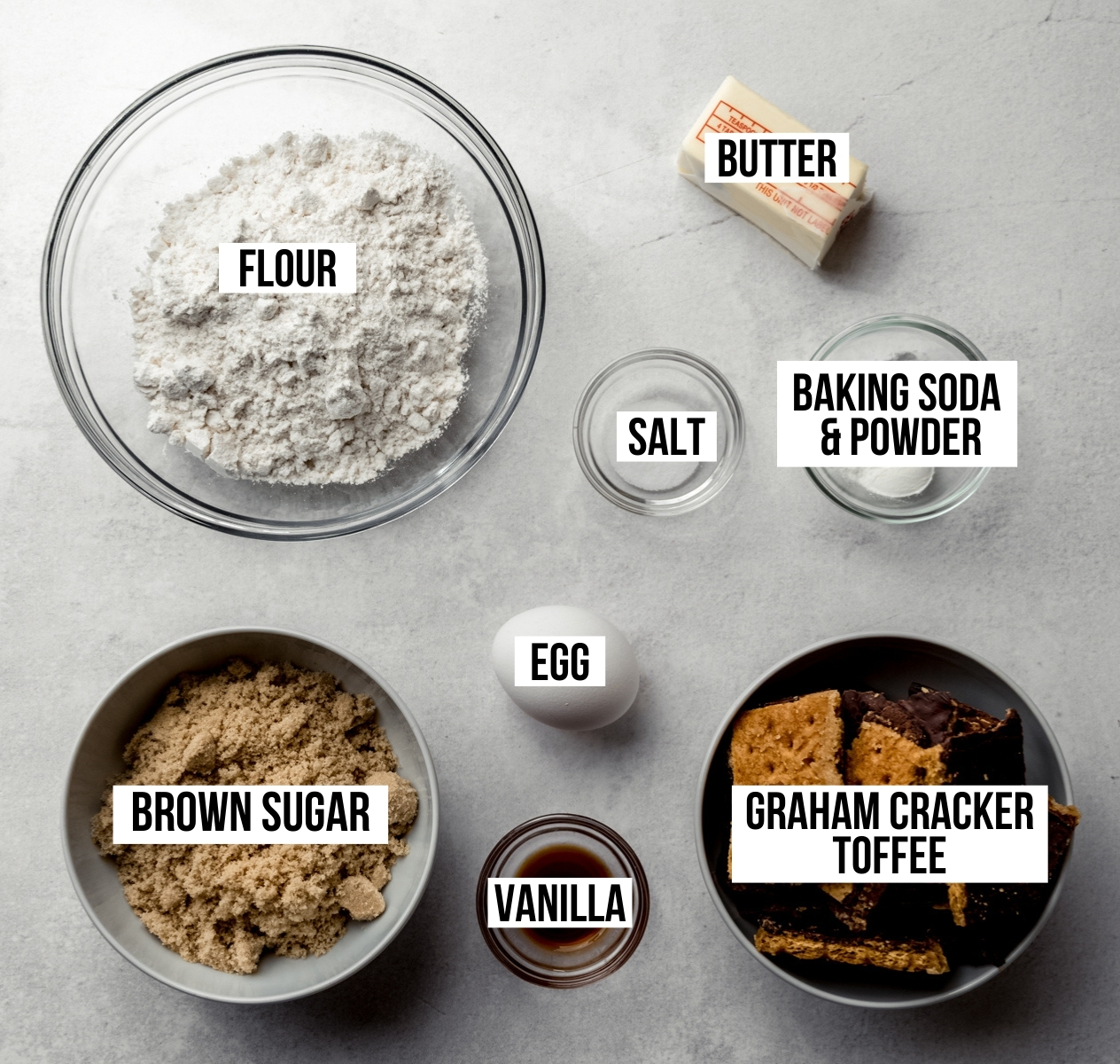 Aerial photo of ingredients to make graham cracker toffee cookies with text overlay labeling each ingredient.