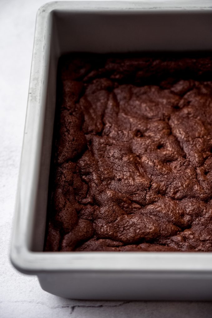 A chocolate cookie bar base baked in a square baking pan.