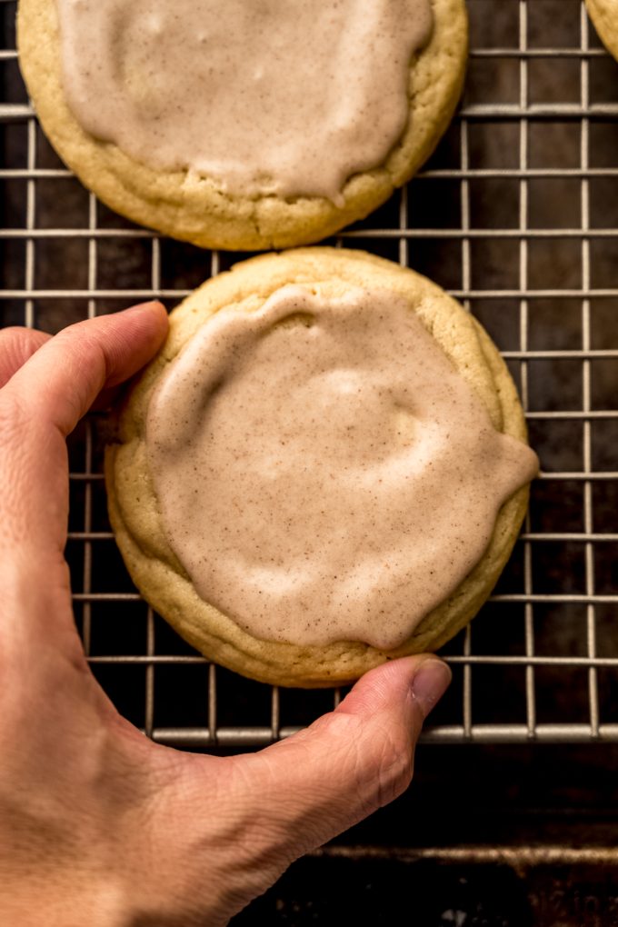 Aerial photo of someone holding a brown sugar Pop Tart cookie on a cooling rack to show size.