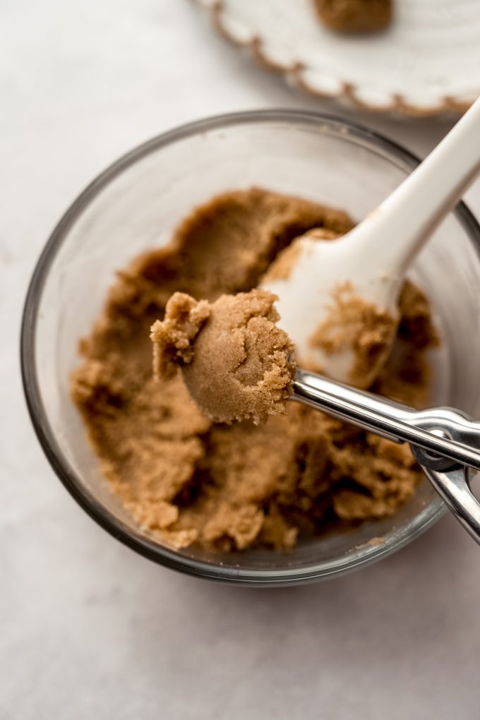 Someone is using a small cookie scoop to portion out brown sugar filling for Pop Tart cookies.