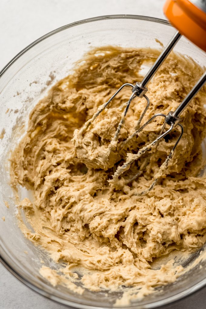 Rice Krispie treat cookie dough in a bowl with electric beaters.