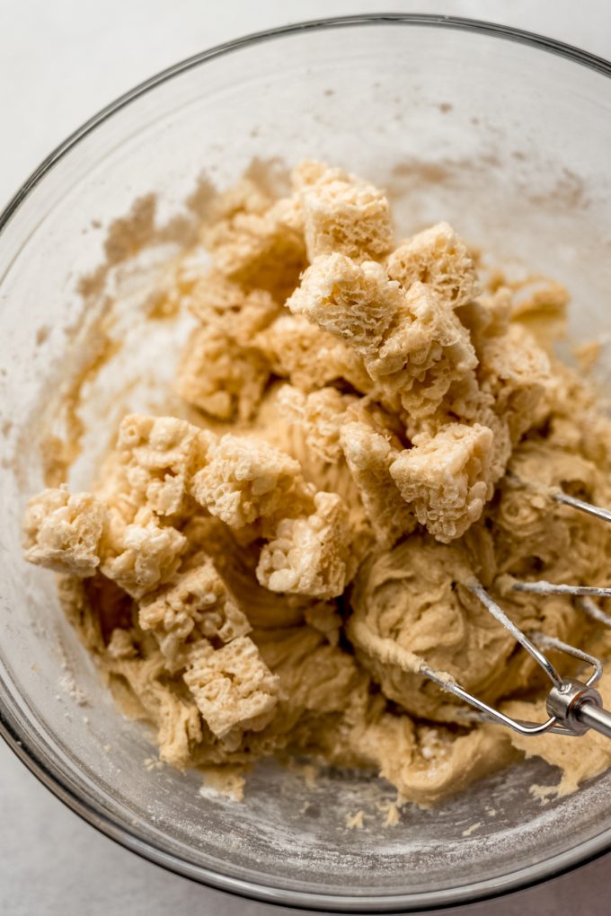 Rice Krispie treat cookie dough in a bowl with electric beaters.