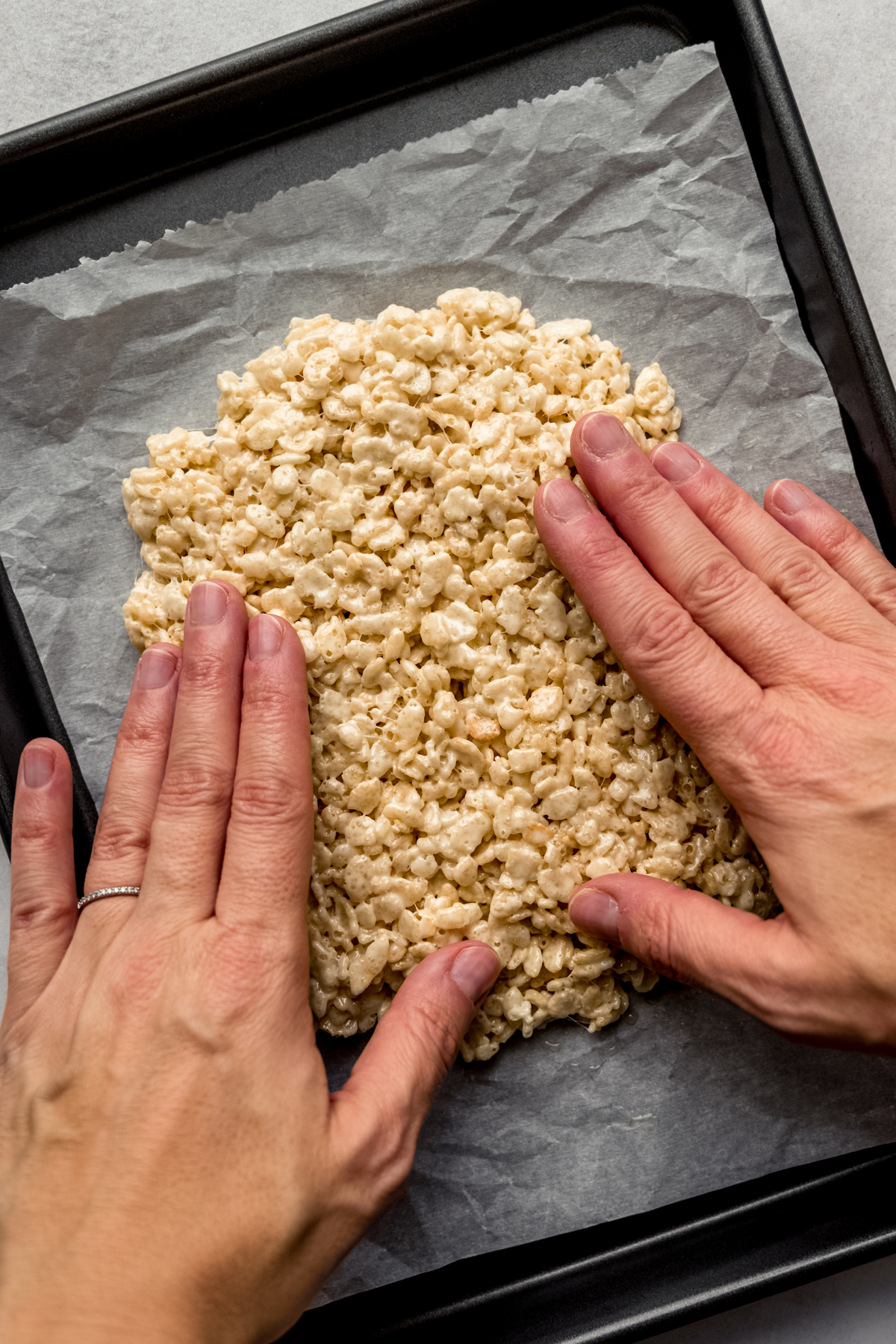 Aerial photo of someone's hands pressing together Rice Krispies treats to make cookies.