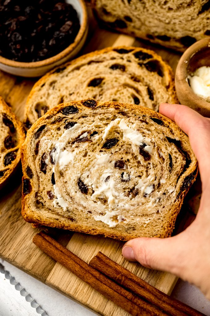 Buttered, sliced cinnamon raisin bread on a surface.