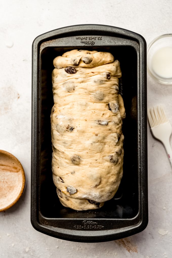Cinnamon raisin bread dough in a baking pan.