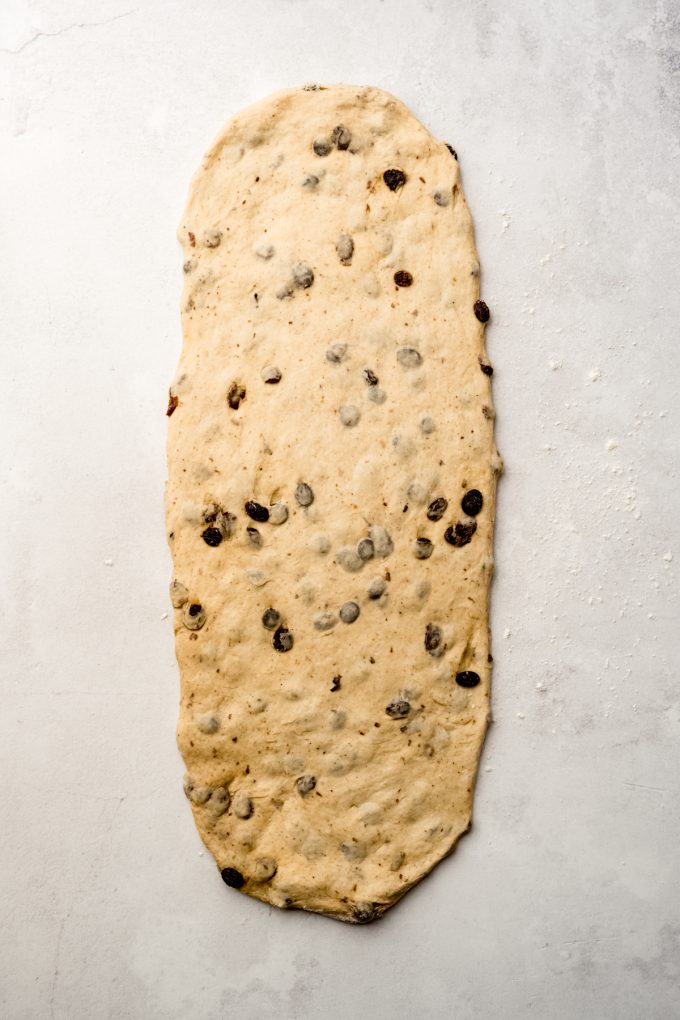 A rectangle of cinnamon raisin bread dough on a surface.