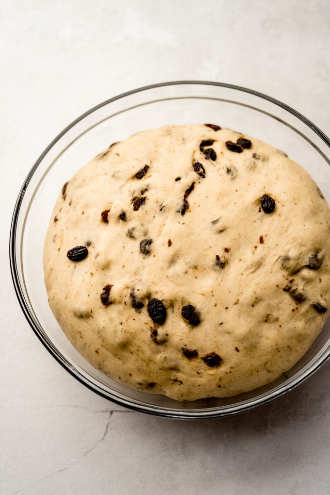 Cinnamon raisin bread dough in a glass bowl.