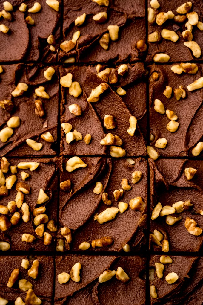 Aerial photo of frosted brownies with walnuts that have been sliced.