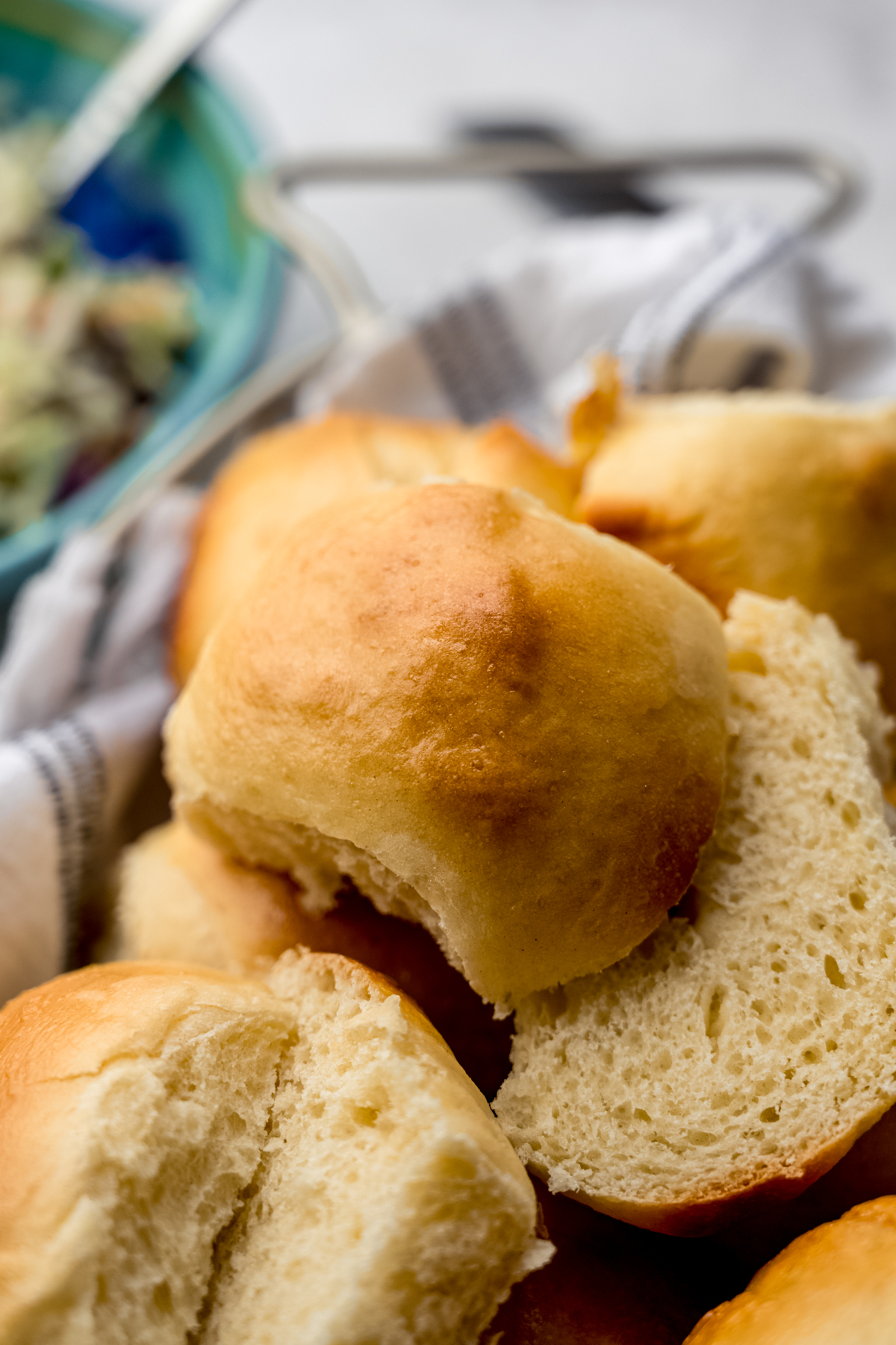 Mini slider buns that have been sliced and are sitting in a bread basket.