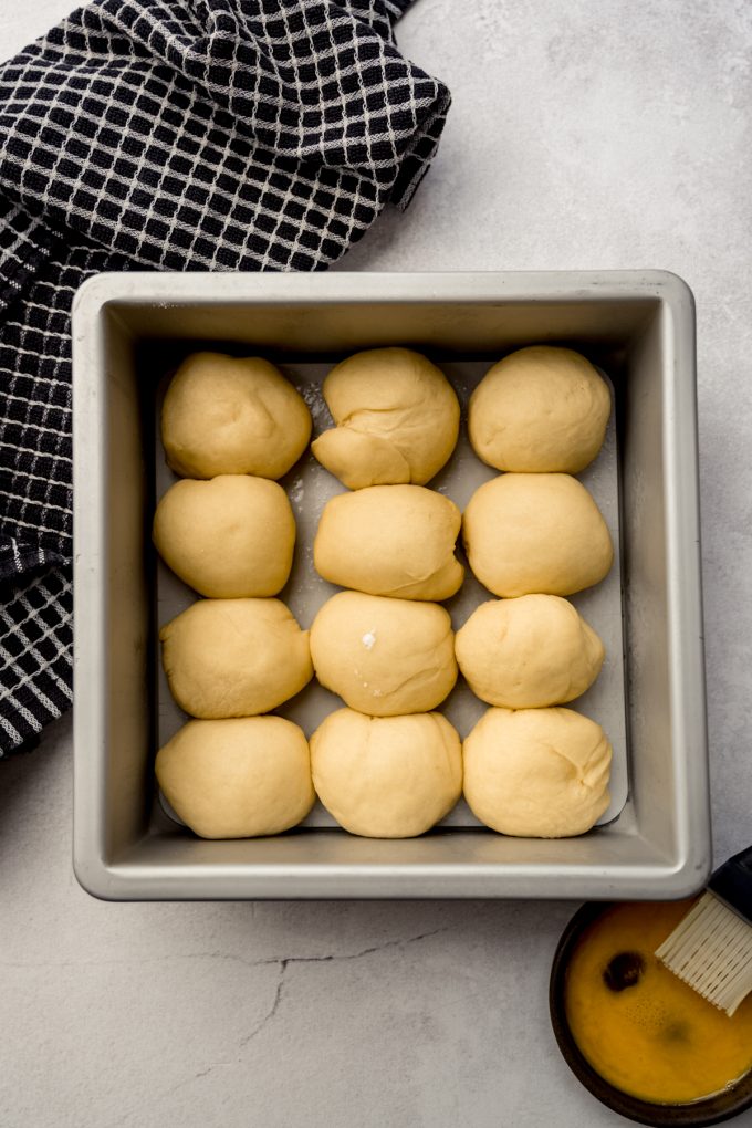 Aerial photo of slider dough balls in a baking pan after they have risen.