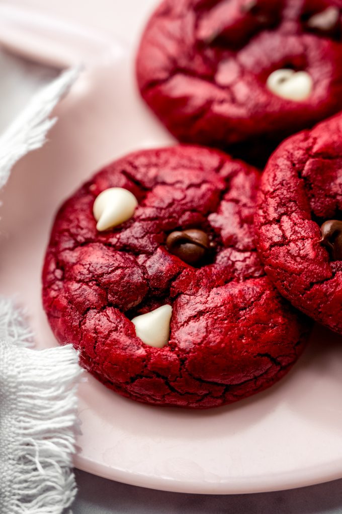 Red velvet chocolate chip cookies on a plate.