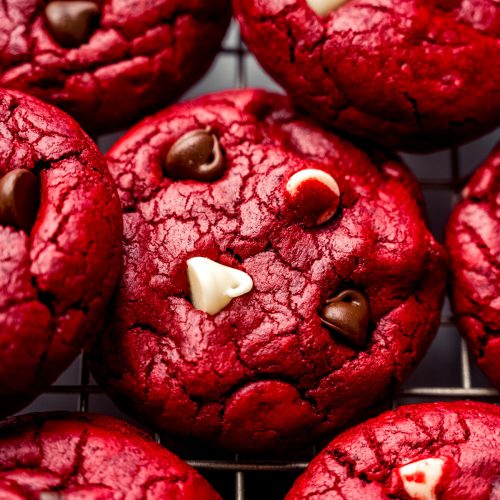 Red velvet chocolate chip cookies on a cooling rack.