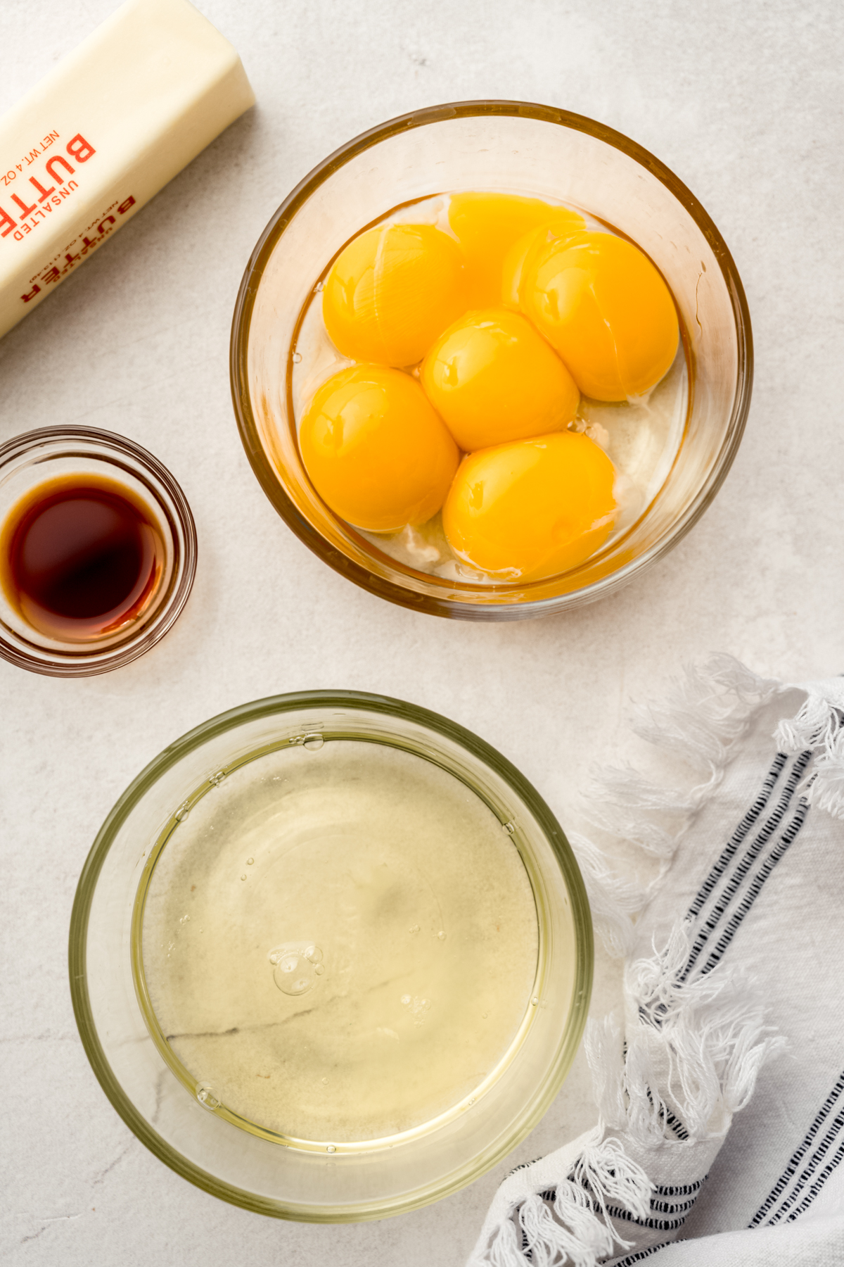 Aerial photo of a bowl of egg whites and a bowl of egg yolks.