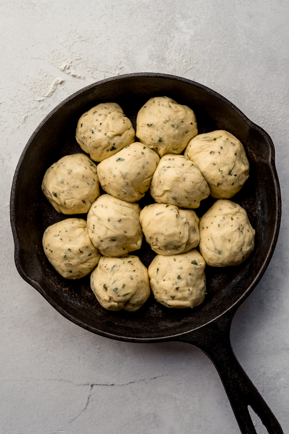 Aerial photo of a skillet with herbed dinner rolls in it.