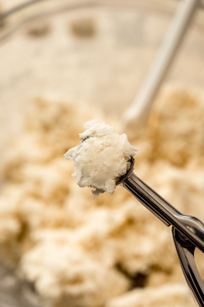 A scooper with the filling of Irish potato candy in it.