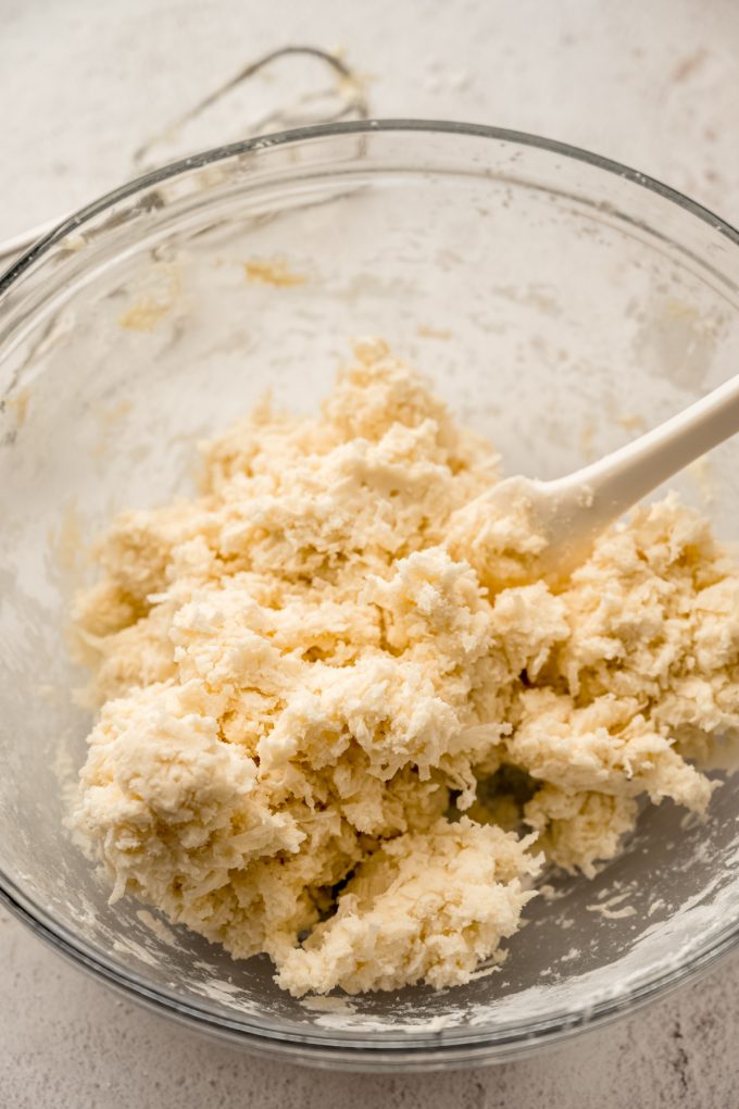 A bowl of the filling for Irish potato candy with a spatula in it.