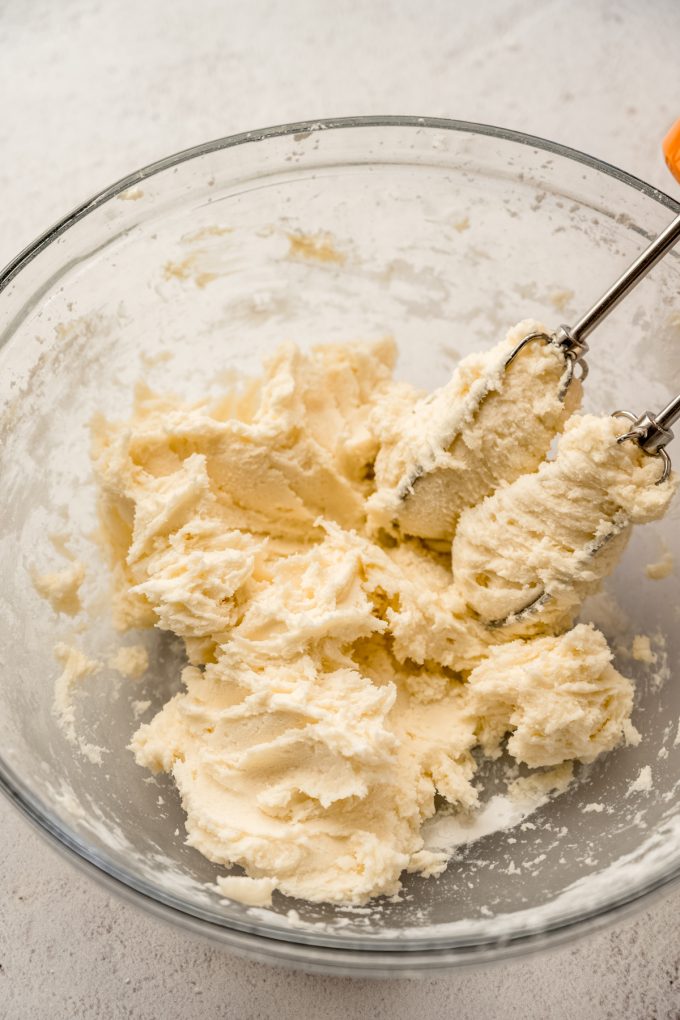 A bowl of the filling for Irish potato candy with a electric beaters it in.