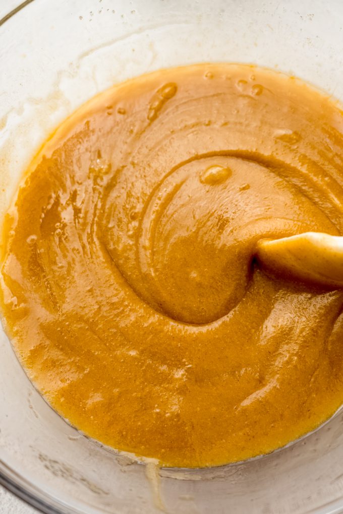 Sourdough discard chocolate chip cookie dough in a bowl being stirred with a spatula.