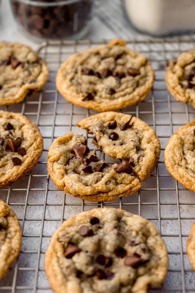 Aerial photo of sourdough chocolate chip cookies on a cooling rack and one has been broken in half.
