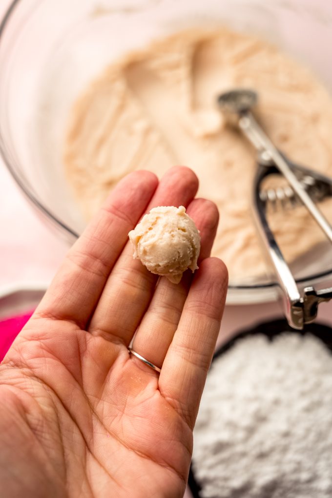 A ball of strawberry truffle filling in someone's hand.