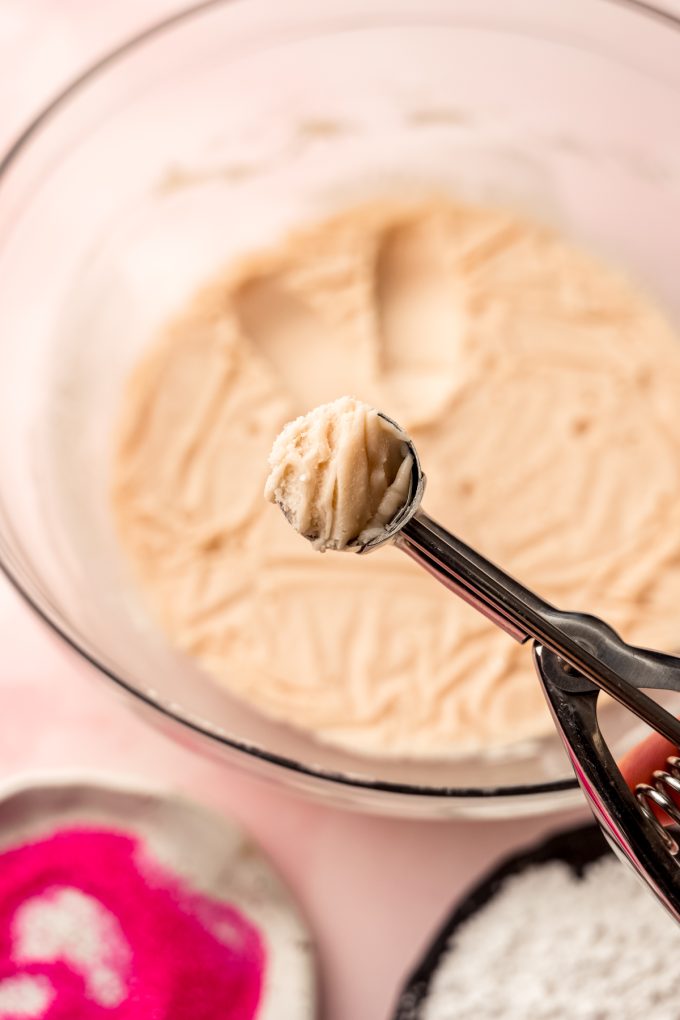 A ball of strawberry truffle filling in the head of a scooper.
