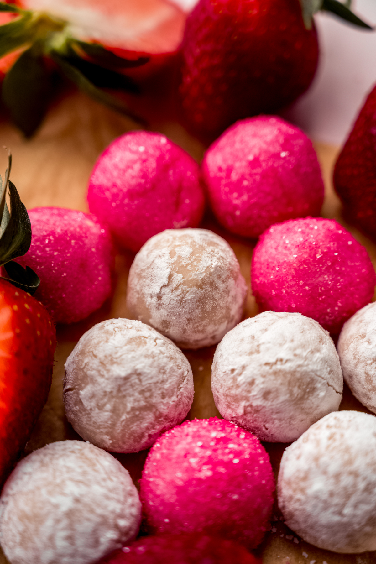 Strawberry truffles on a surface.