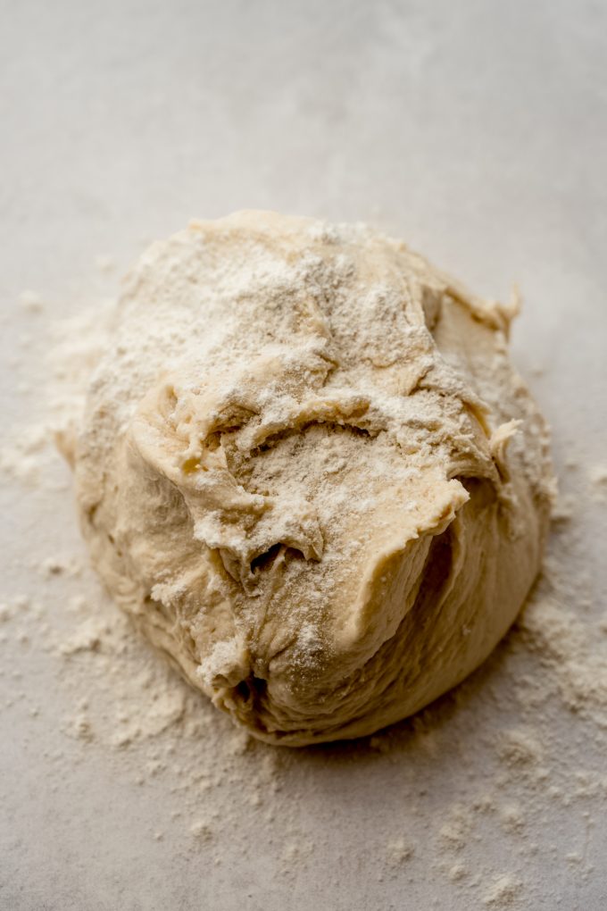 A gathering of yeasted bread dough on a surface before kneading.