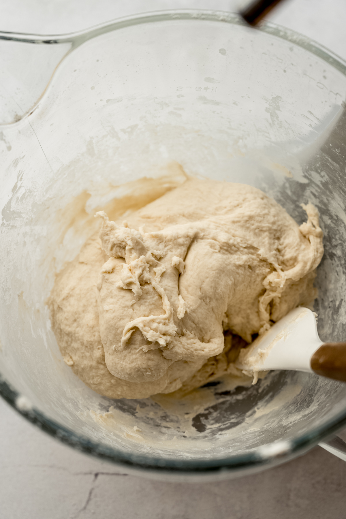 Homemade breadstick dough in a bowl with a spatula.
