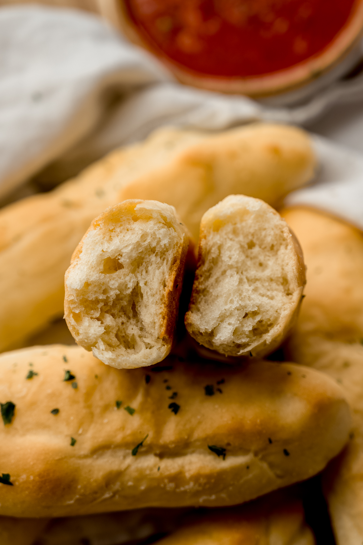 A breadstick broken in half so you can see the inside of the dough.
