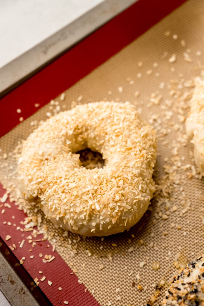 A homemade onion bagel on a baking sheet.