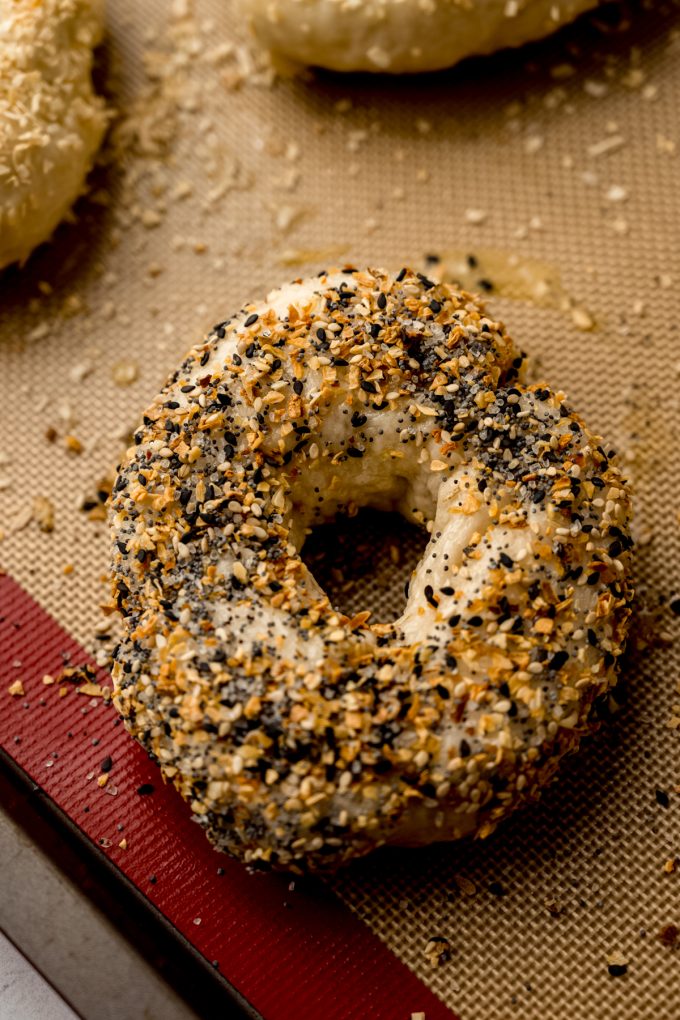 A homemade everything bagel on a baking sheet.