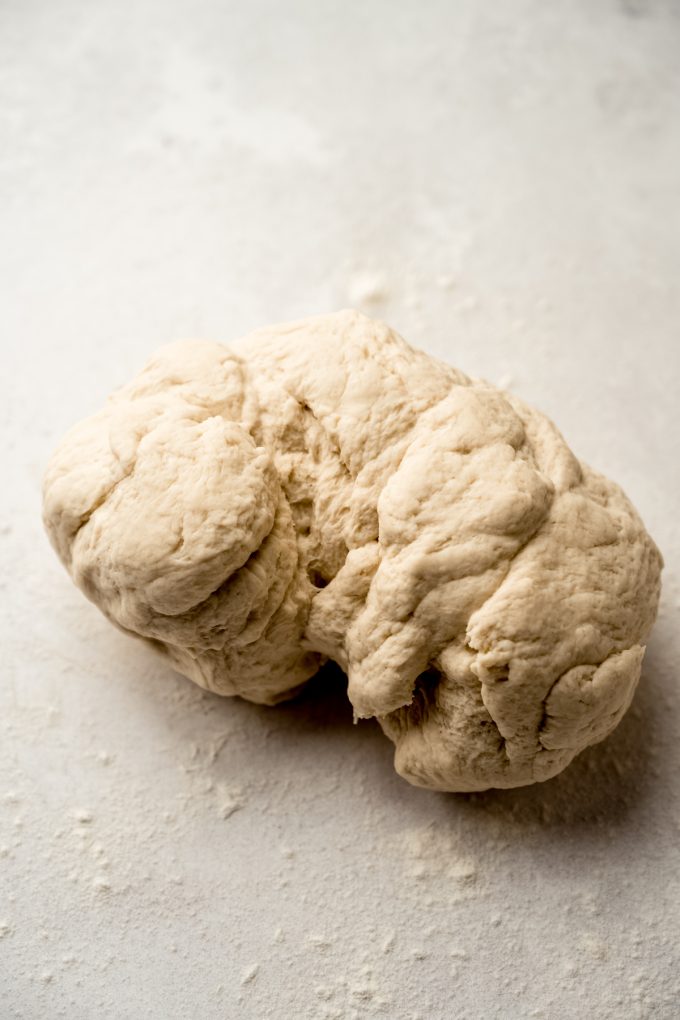 Bagel dough on a surface before kneading.